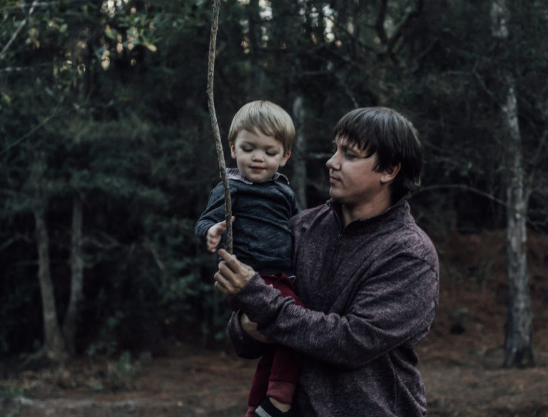 dad holding child while playing outside
