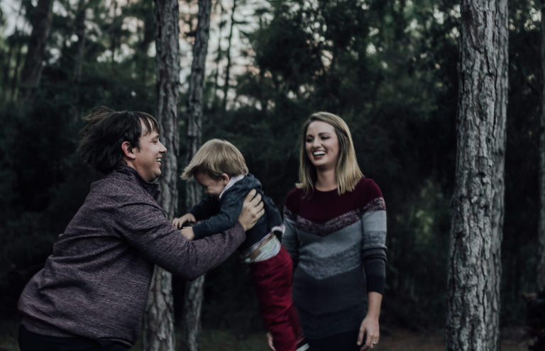 parents laughing and playing with child