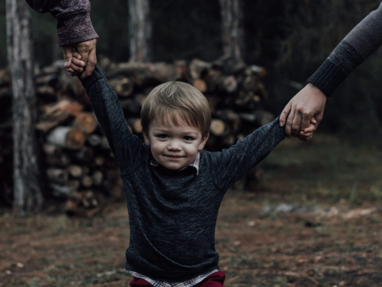 parents holding child's hand