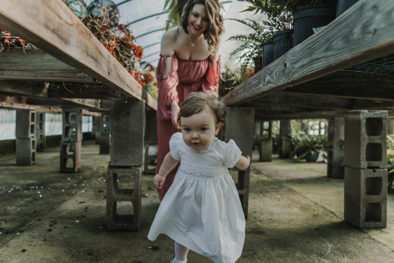 toddler running in greenhouse 